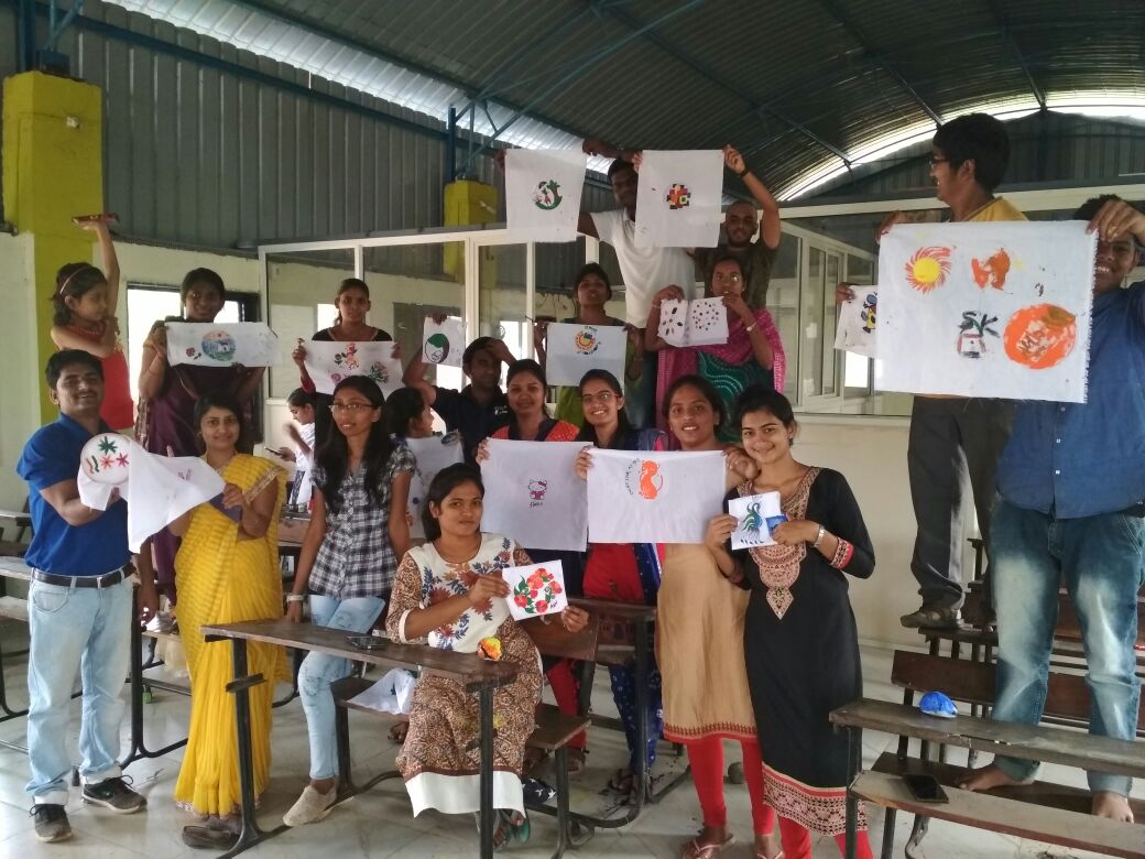 Persone durante un laboratorio creativo di pittura su stoffa e pietre, foto illustrativa non scattata a Oasi Creativa